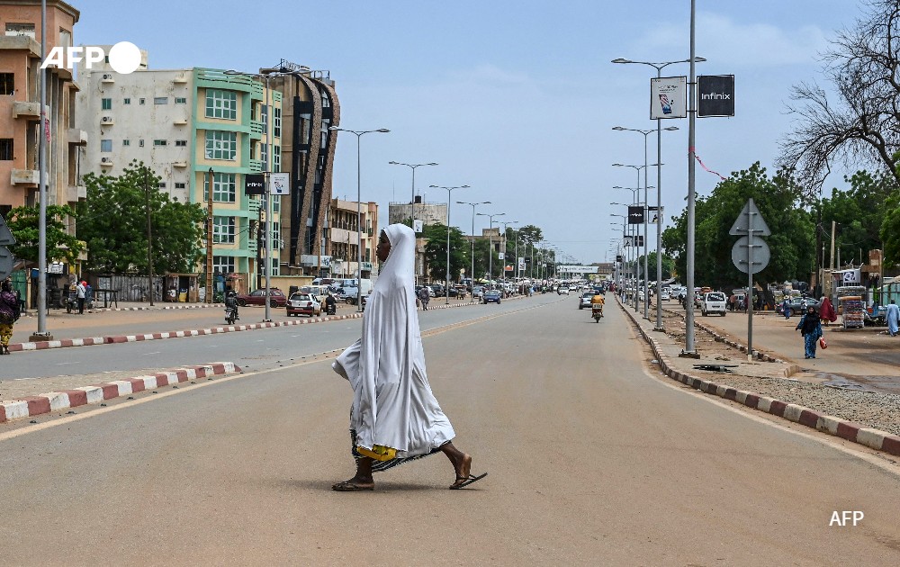 A woman walks across a road in Niamey